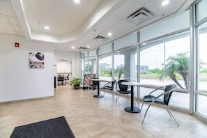 A spacious lobby with large windows, a reception desk, and modern chairs. - 3 Pet-Friendly Ingleside Rooms w/ Kitchen, Free Parking | Onsite Pool Access (Ingleside)