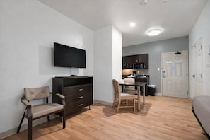 A hotel room with a TV, a desk with chairs, a kitchenette, and a bed. - 4 Budget-Friendly Rooms for Ingleside Stay! Kitchen, Free Parking, Onsite Pool (Ingleside)