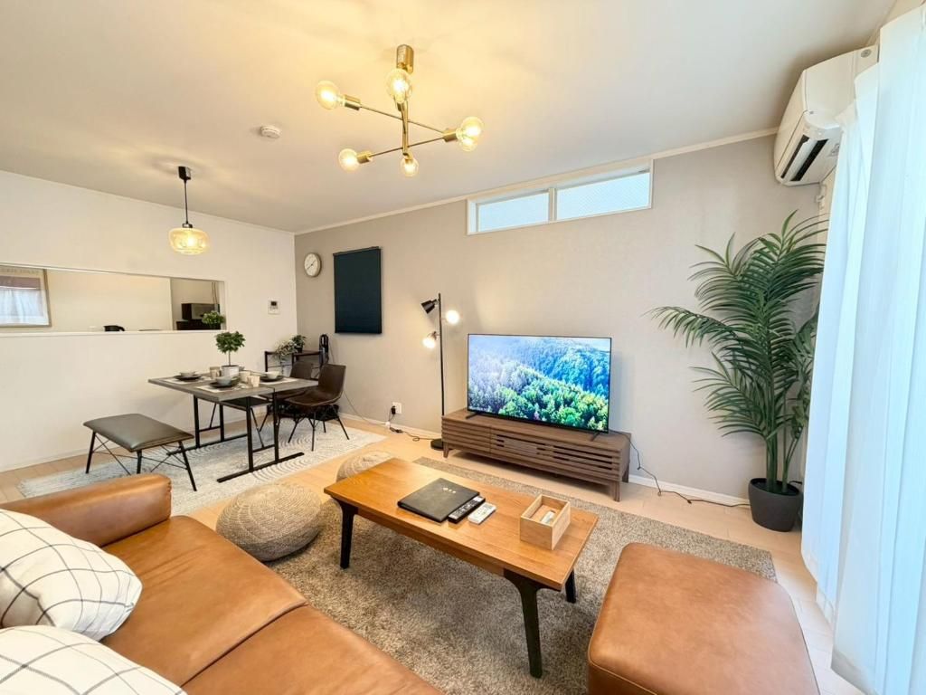 A modern living room with a sofa, coffee table, and a flat-screen TV.