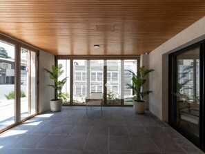 A modern interior with a wooden ceiling, large windows, and potted plants. - Cozy 1-bedroom apartment with AC in lovely Moema neighbourhood in São Paulo (São Paulo)
