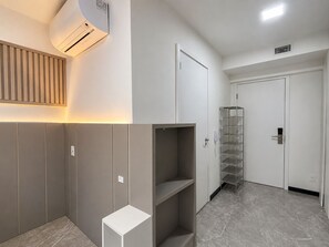 Ein moderner Flur mit eingebautem Kleiderschrank, einer Regaleinheit und einer Tür mit Metallregalen.