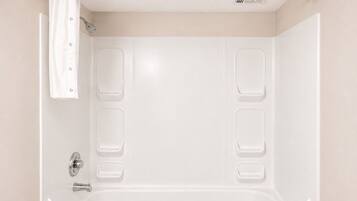 Une salle de bain moderne équipée d’une baignoire, d’une douche et d’un porte-serviettes.