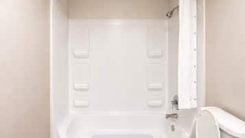 A bathroom with a bathtub, a toilet, and a shower curtain.