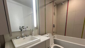 A modern bathroom with a white sink, mirror, and toilet. - StayToronto - The Entertainment Suites (Toronto)