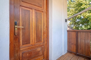 A wooden door with a modern lock and a metal handle.