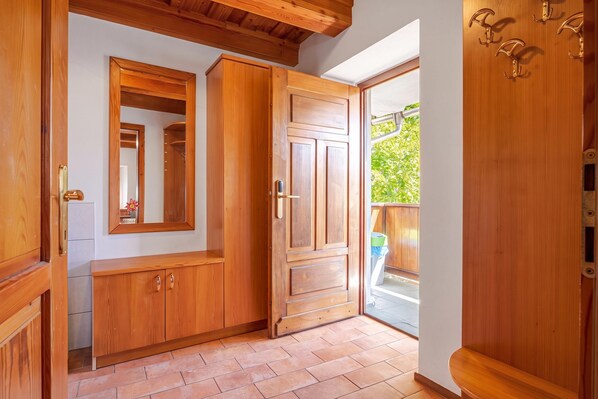 Un intérieur en bois comprenant une armoire, un miroir et une porte donnant sur un espace extérieur.