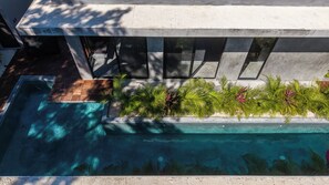 A rooftop pool with a clear view of the sky and surrounding buildings. - Casa Santo: Private Villa with Swim-up Suites, Courtyard Pool & Concierge (Tulum)