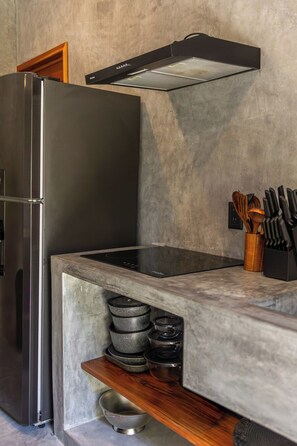 A kitchen with a built-in stainless steel refrigerator, a black range hood, and a wooden countertop with kitchen utensils. - Casa Santo: Private Villa with Swim-up Suites, Courtyard Pool & Concierge (Tulum)
