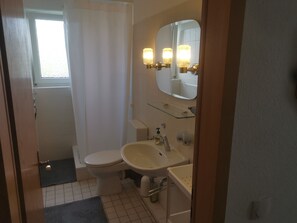Ein Badezimmer mit Toilette, Waschbecken und Spiegel.