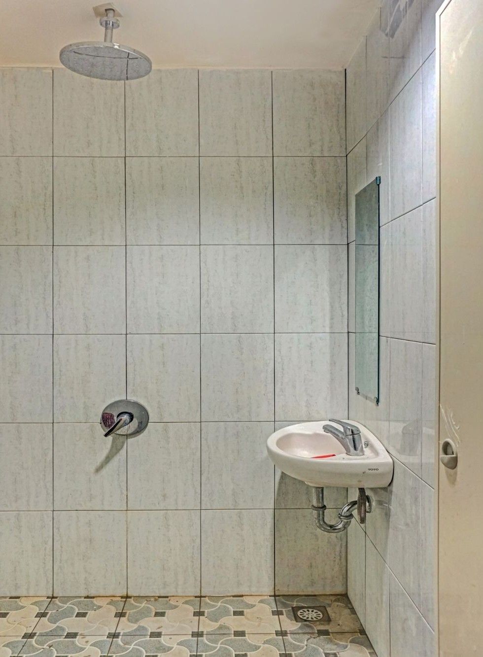 Un baño con ducha, lavabo y espejo.