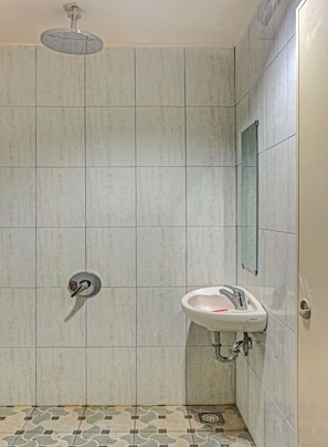 Ein Badezimmer mit Dusche, Waschbecken und Spiegel.