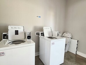 A laundry room with two front-loading washing machines and a dryer. - Luxury glamping suite near beaches & OWA, POOL! (Foley)