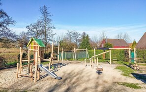 A playground with a slide, swings, and a climbing structure. - Pet friendly home in Wemeldinge with sauna (Wemeldinge)
