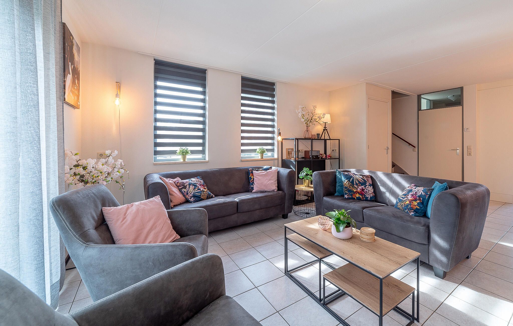 A modern living room with two sofas, a coffee table, and a bookshelf.