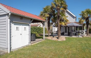 Ein Wohnhaus mit Garage, einer überdachten Terrasse und einem Rasen.