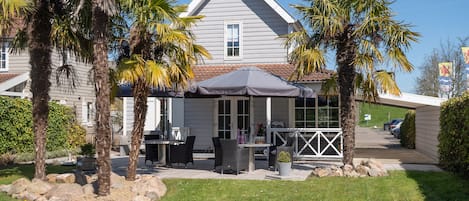 A house with a patio area featuring outdoor furniture and a covered seating area.