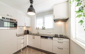 A modern kitchen with a built-in oven, a coffee maker, and a dishwasher. - Awesome home in Wemeldinge with sauna (Wemeldinge)