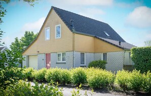 A two-story house with a sloped roof, a brick exterior, and a front door. - Awesome home in Wemeldinge with sauna (Wemeldinge)