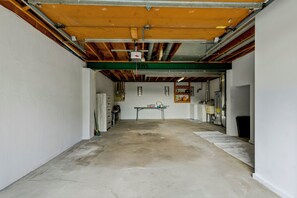 A spacious, unfinished garage with exposed beams and a concrete floor.