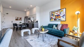 Un espai de vida modern amb menjador, cuina i sofà.
