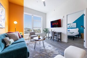 A modern living room with a sofa, a coffee table, and a TV mounted on the wall.