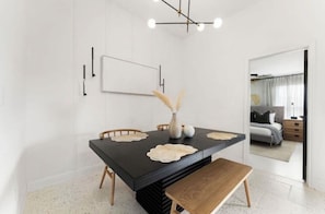 A modern dining area with a black table, wooden chairs, and a bench. There is a vase with dried pampas grass on the table. - The Wild Tumbleweed/ 3-bedroom house in quaint Lubbock- Best of the West (Lubbock)