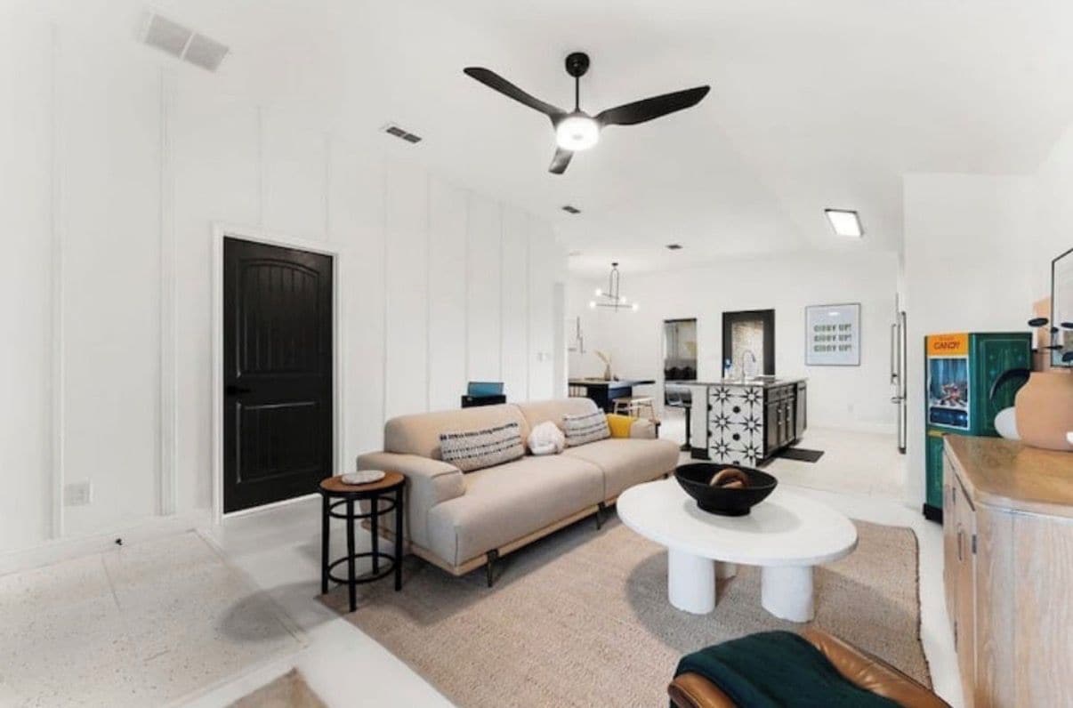 A modern living room with a sofa, coffee table, and a ceiling fan.