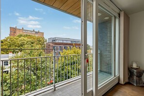 Ein Balkon mit Blick auf eine Stadtlandschaft, einschließlich Gebäude und Bäume.