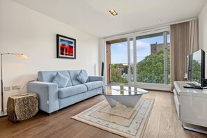 Ein modernes Wohnzimmer mit einer Couch, einem Couchtisch und einem Fernseher.