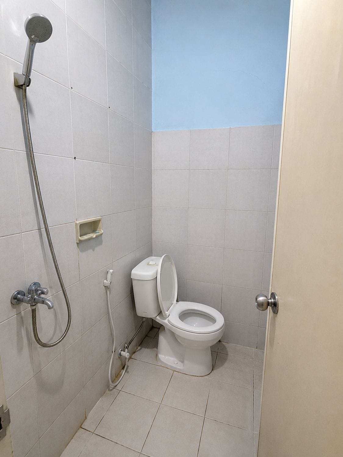 Un baño pequeño con inodoro, ducha y lavamanos.