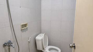 Un baño pequeño con inodoro, ducha y lavamanos.