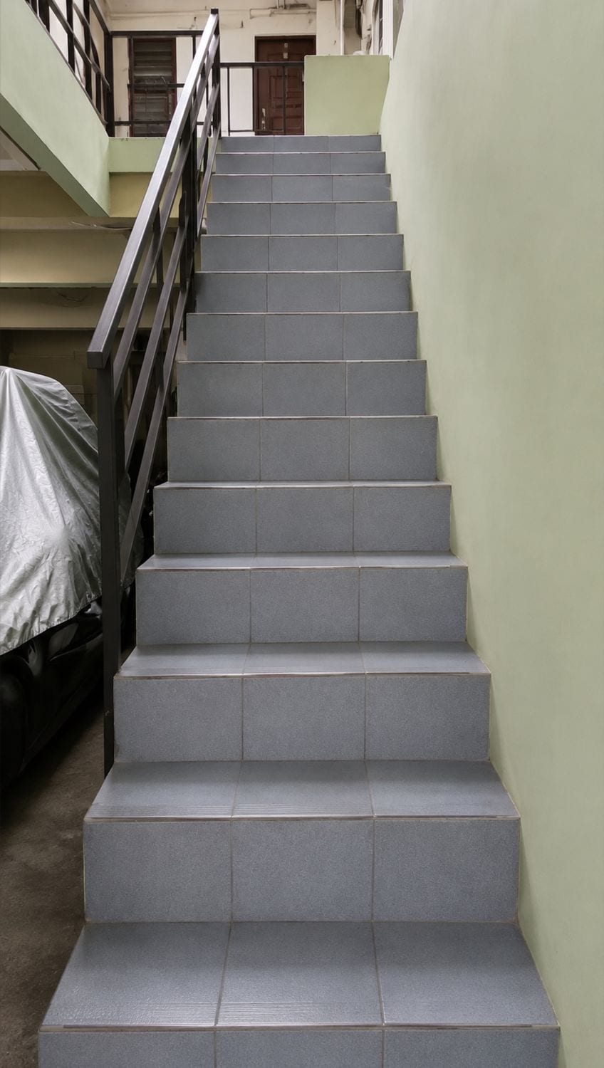 A staircase with a metal handrail leading to an upper floor.