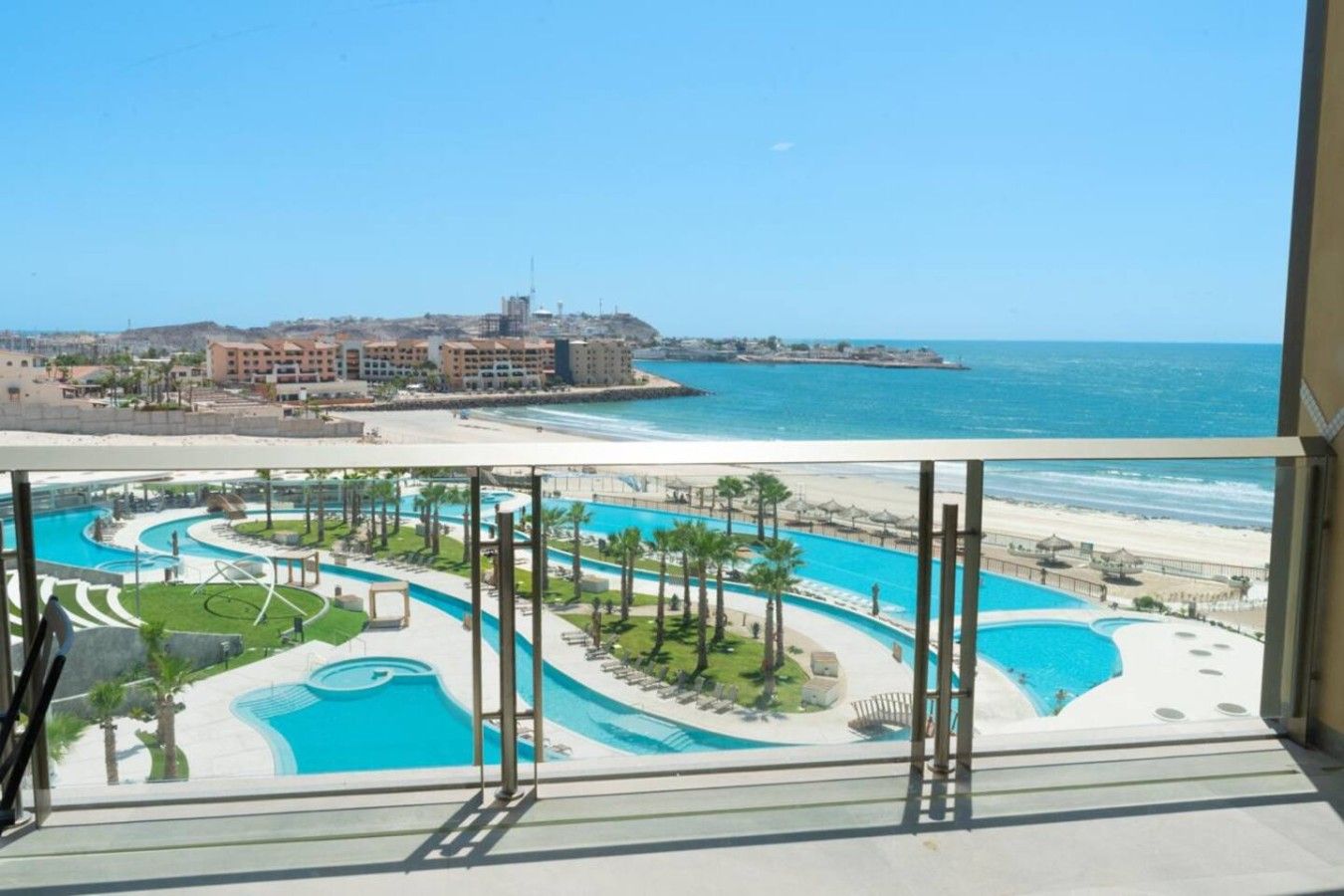 Un resort con zona de piscina, playa y vista al océano.