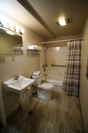 Een badkamer met een wastafel, toilet en bad.