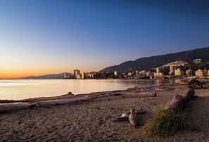 Uma praia com um horizonte urbano ao fundo, mostrando uma mistura de edifícios residenciais e comerciais.
