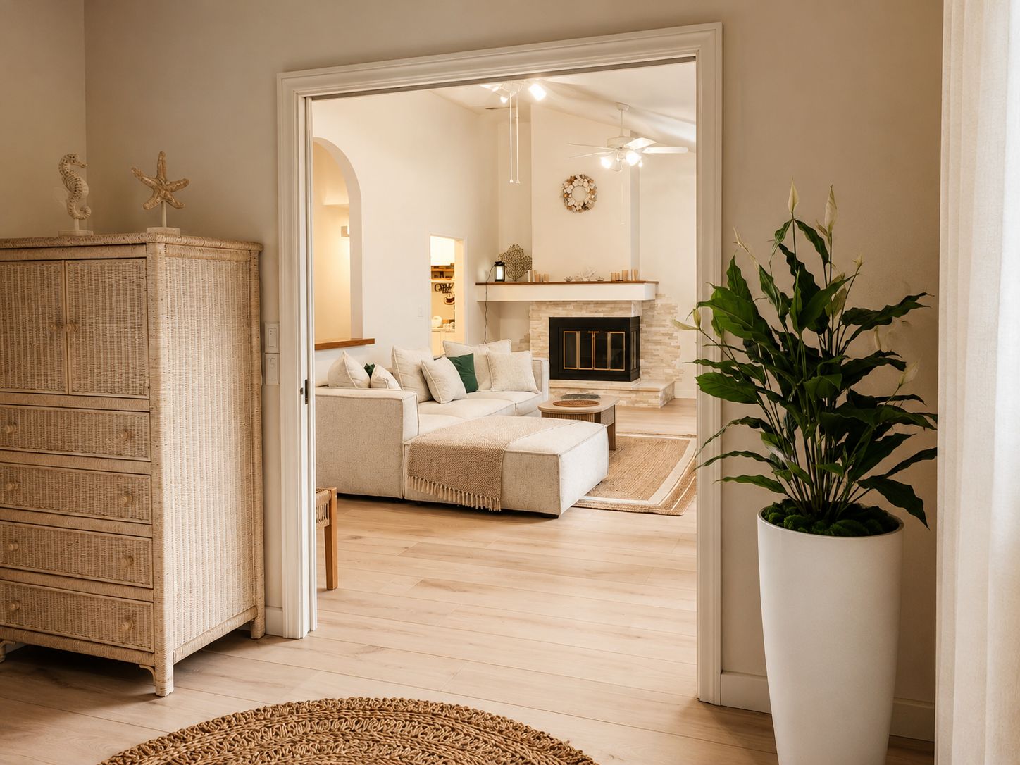 A living room with a sofa, a coffee table, a fireplace, and a large potted plant.