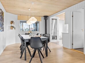 Eine moderne Küche mit Kochinsel, Edelstahlgeräten und Blick ins Freie.