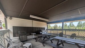 An outdoor patio with picnic tables, a grill, and a barbecue area. - Ski-to-Door Condo, Kimberley Alpine Resort (Kimberley)