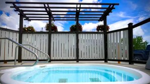 A swimming pool with a pergola overhead, surrounded by a white fence and potted plants. - Ski-to-Door Condo, Kimberley Alpine Resort (Kimberley)
