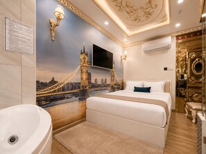 A hotel room with a bed, a large window with a cityscape view, a wall-mounted TV, and a bathroom with a sink and mirror. - Amory Royal Hotel (Ho Chi Minh City)