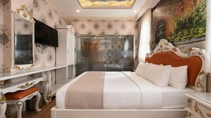 Un dormitorio con cama, televisor, armario y un cuadro en la pared.