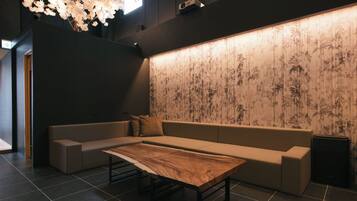 A modern interior with a sofa, a wooden table, and a wall with a bamboo pattern.