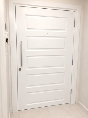 Una puerta blanca con manija y cerradura.