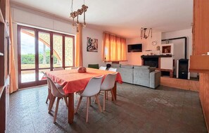 A dining area with a table and chairs, a sofa, a fireplace, and a television. - Gorgeous home in Arenella with house sea view (Arenella)