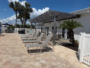 A poolside area with lounge chairs and a covered seating area. - Ocean Front w/Direct Pvt Access, Free Beach Setup! New Owner, Pre-Reno Special! (Destin)