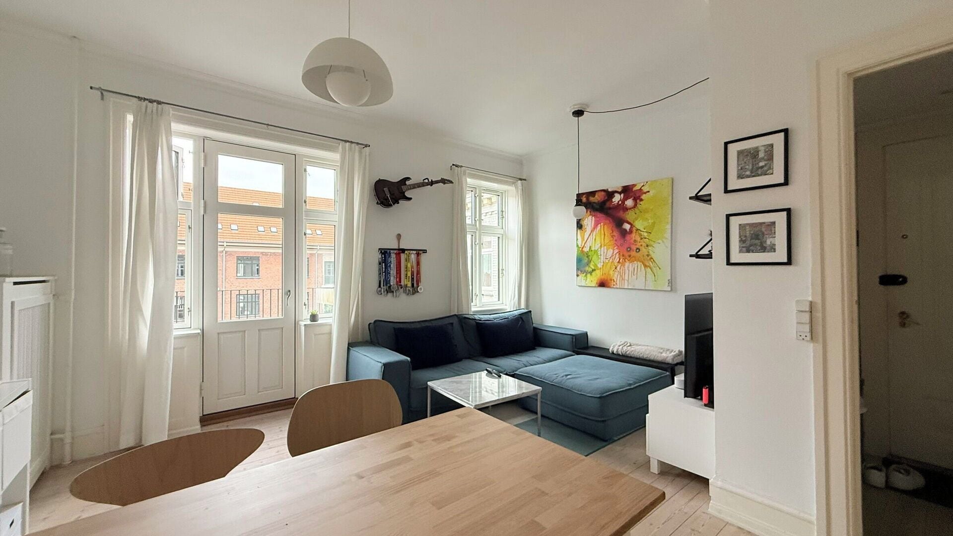 Een moderne woonkamer met een bank, een eettafel en een televisie.