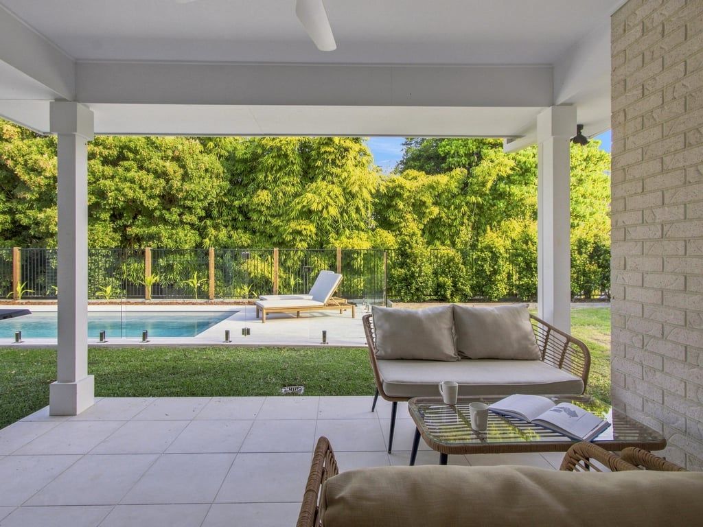 Un espace extérieur abrité comprenant une piscine, un canapé et une table.