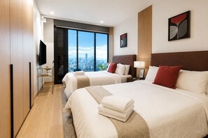A hotel room with two beds, a TV, and a city view. - Premium Loft Reforma | View + Pool + Gym (Mexico City)