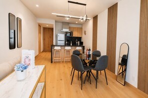A modern kitchen with a dining area, wooden flooring, and a mirror. - Skyline Views in Reforma | Pool, Gym, Central (Mexico City)