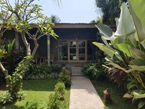 A modern building with a concrete pathway leading to a glass door entrance.